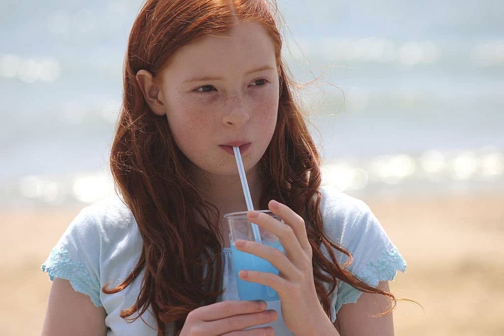 girl drink blue slushies beach