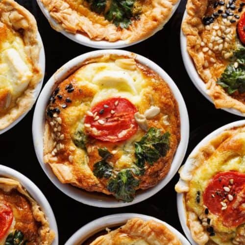 mini vegetarian quiches stuffed with spinach, cherry tomatoes and cheese in a casserole dishes