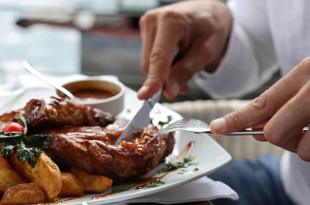 man eating grilled pork spare ribs