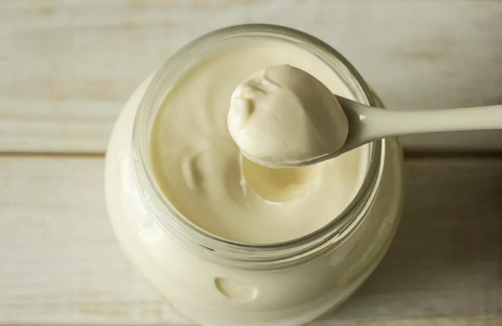 mayonnaise in a glass jar with-a-spoon