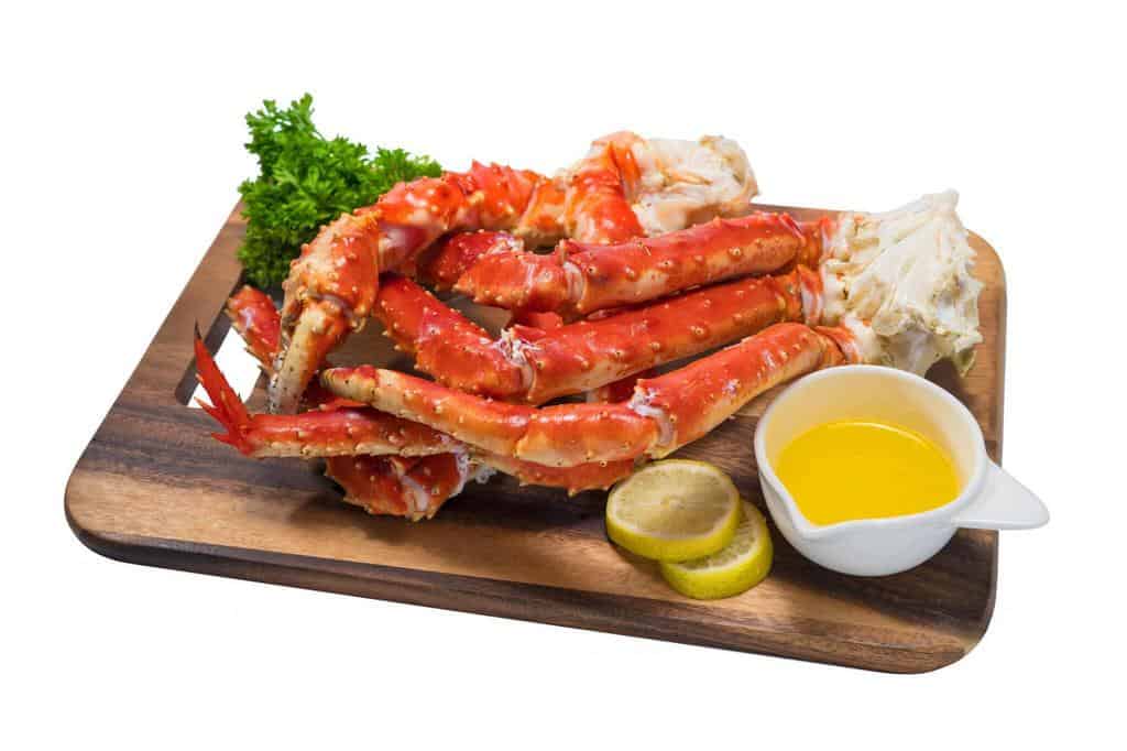 cooked organic alaskan king-crab-legs with butter and lemons