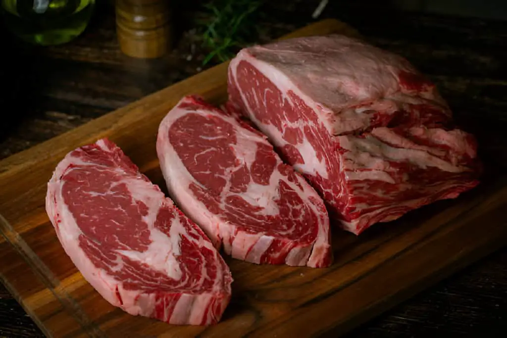 chunk of ribeye steak on wooden board