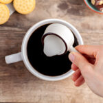 adding creamer into black coffee