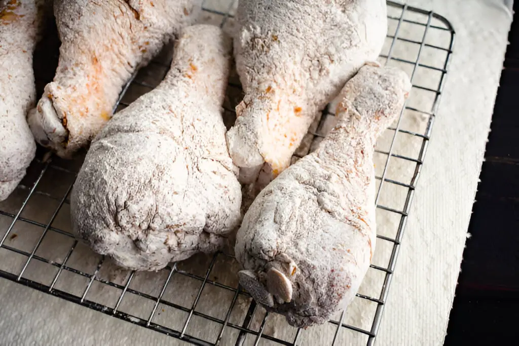 raw floured and spiced chicken drumsticks