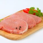 raw pork loin chops with spices-on-a-cutting-board