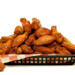 spicy glazed chicken wings in a black basket