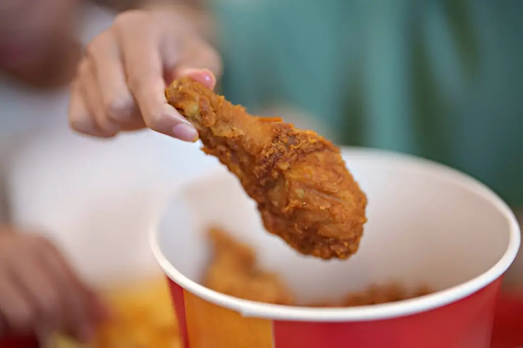 taking a fried chicken drumstick