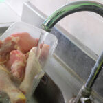 thawing frozen chicken meat-on-running-water