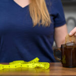 woman holds brews a bag of tea and herbs