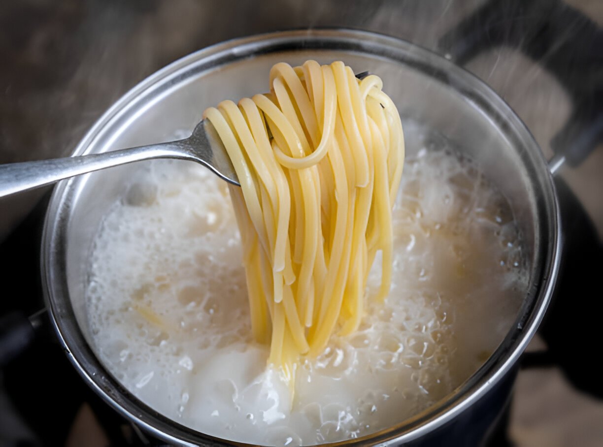 yellow noodles or spaghetti cooking in boiling water