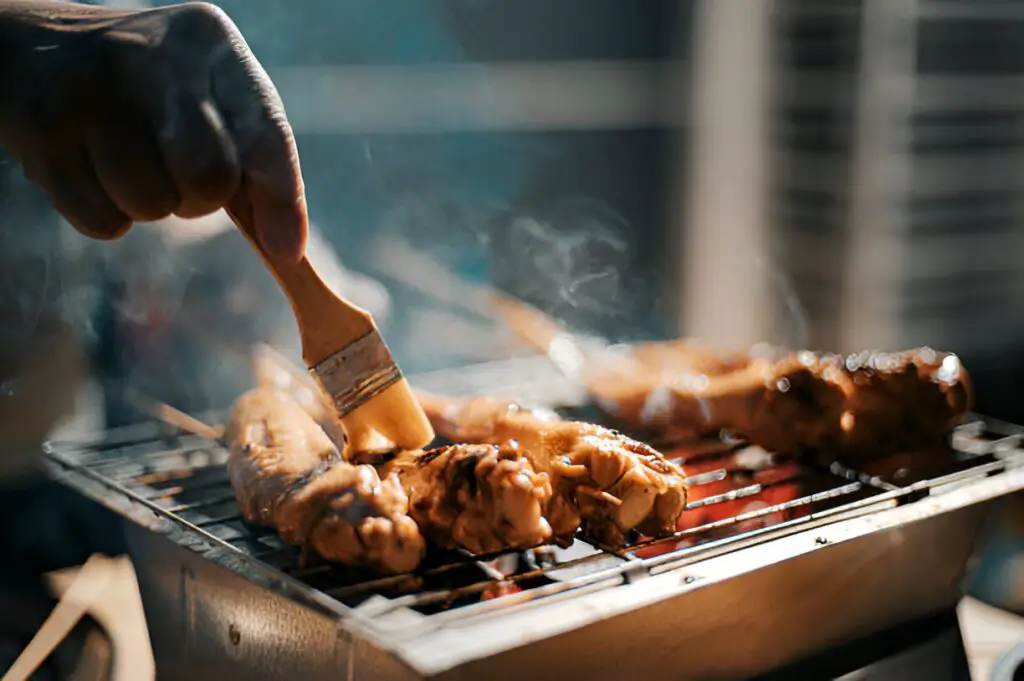 bbq party gathering with food preparation brushing and applying oil
