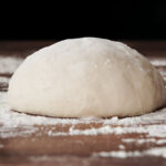 homemade dough ball for pizza on floured