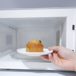 putting a cupcake into a microwave oven