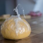 homemade pasta dough wrapped in plastic food wrap