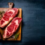 raw beef steak fillets on dark table