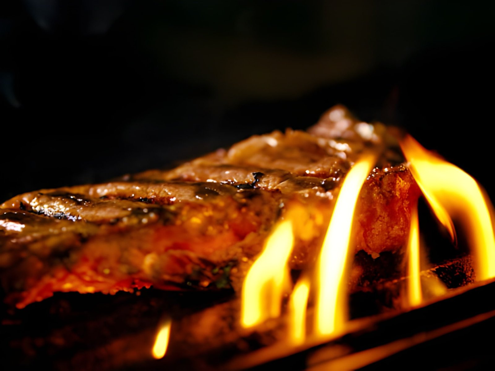 juicy meat steaks on grills flame burning